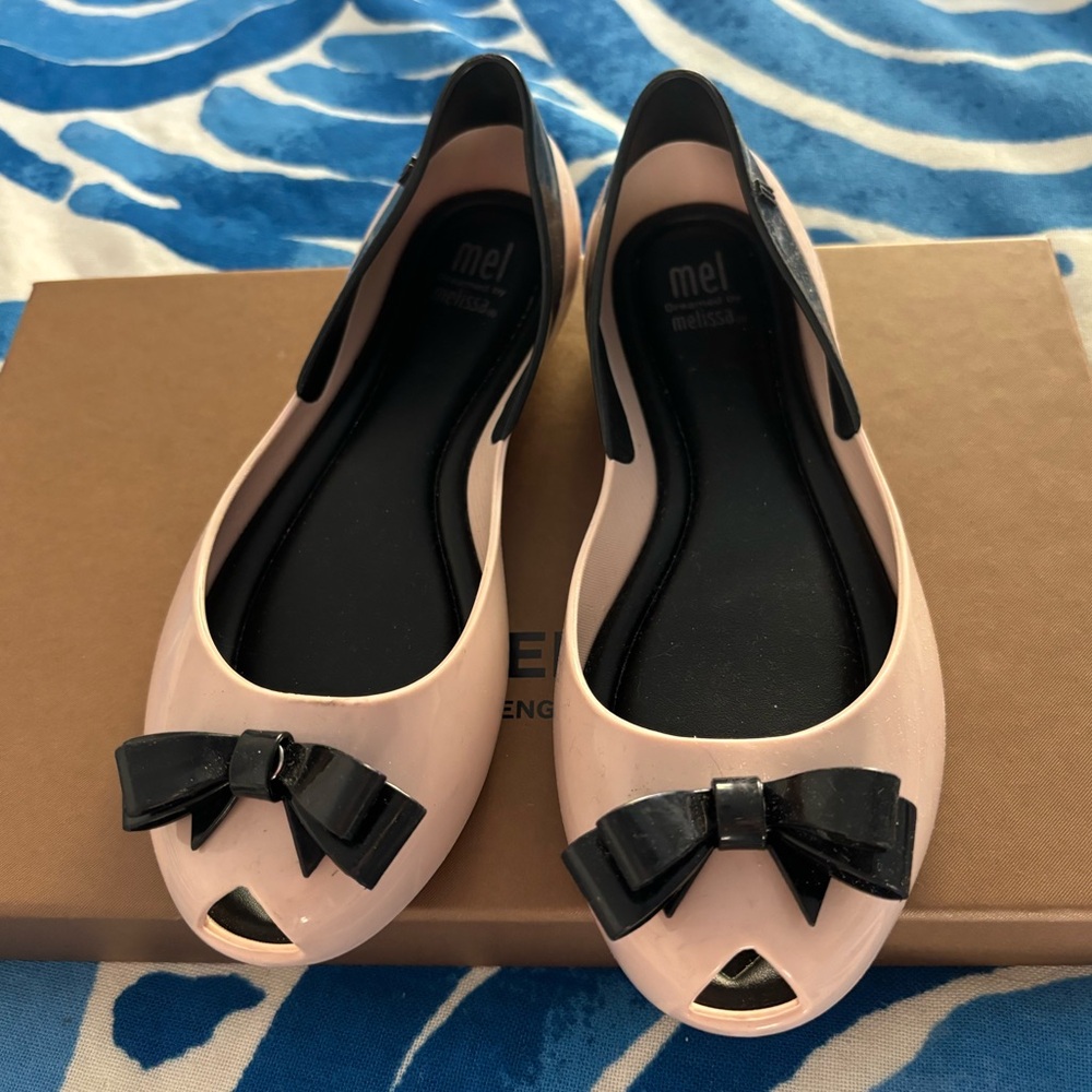 Little girls ballerina flats. Mini Melissa‘s light pink and a black bow on toe